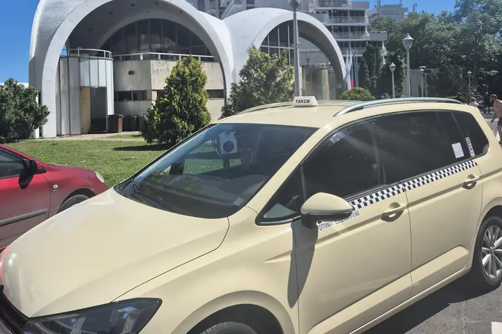 Taxi in front of a white arched building in Albena