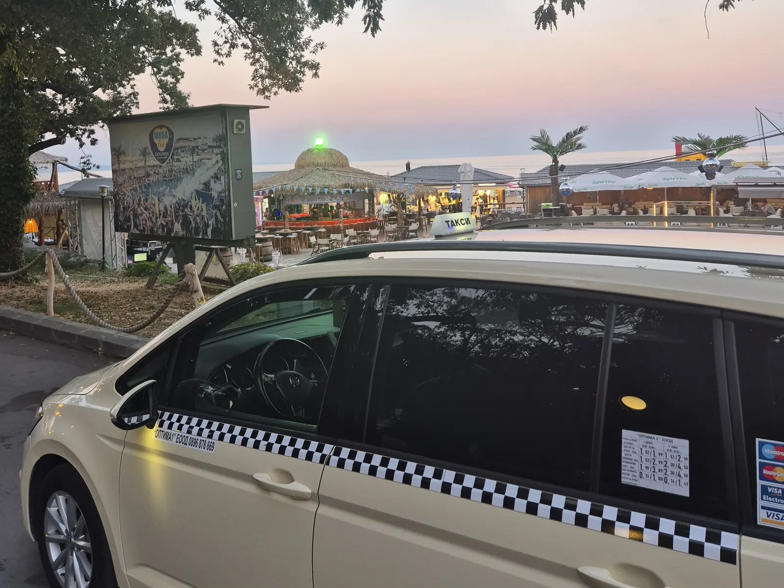 Taxi beside a seaside restaurant in Golden Sands at dusk